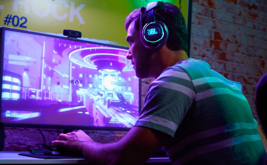 Słuchawki JBL Quantum 810 Bluetooth czarne mężczyzna grający na komputerze ze słuchawkami na uszach