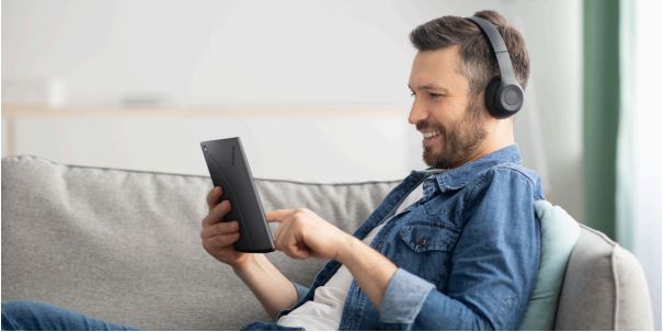 Czytnik e-booków inkBook Solaris fioletowy widok od boku na mężczyznę w słuchawkach trzymający czytnik