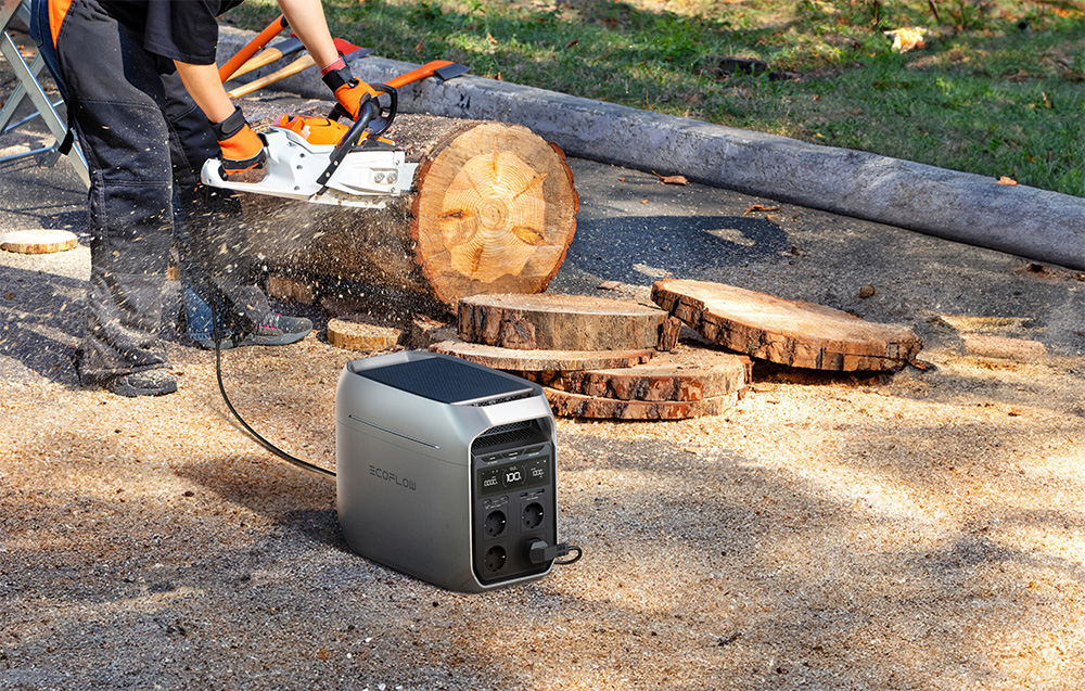 Przenośna stacja zasilania EcoFlow Delta 3 Plus 1024 Wh na ziemi w trakcie ładowania piły do cięcia drewna 