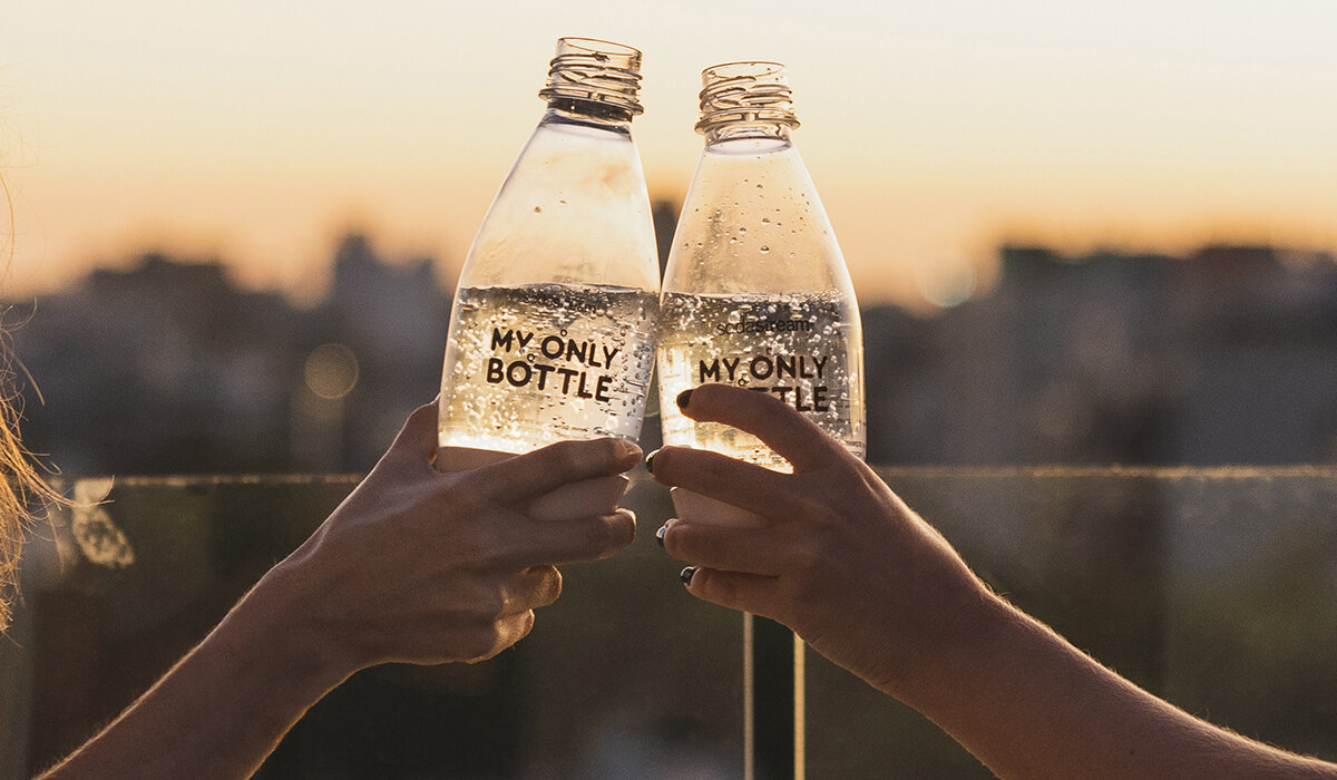 Butelka SodaStream My Only Bottle Różowa widok na dwie butelki z napojem trzymane w dłoniach