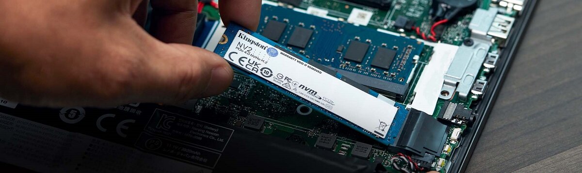 Dysk SSD Kingston NV2 1TB M.2 PCIe Gen4 NVMe widok dłoni montującej dysk w komputerze