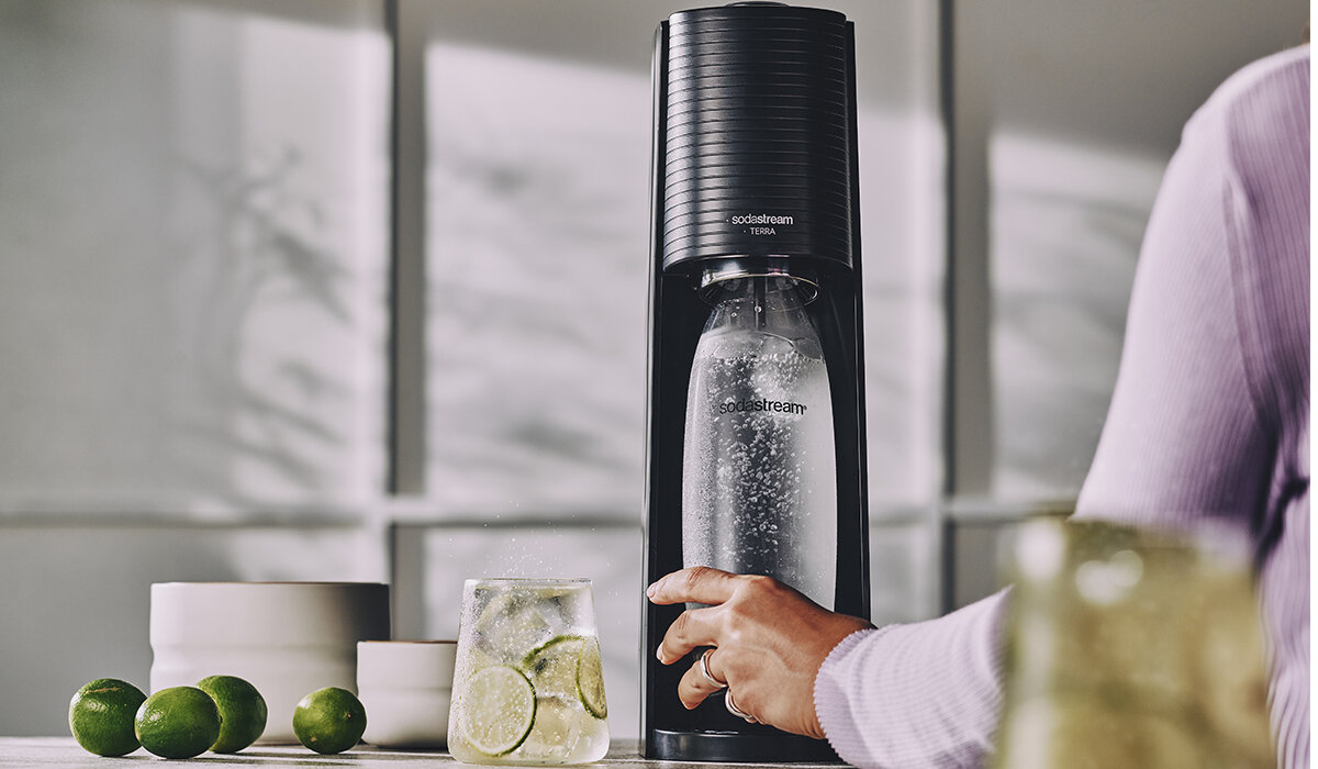 Saturator SodaStream Terra grafika przedstawia kobietę używającą saturatora