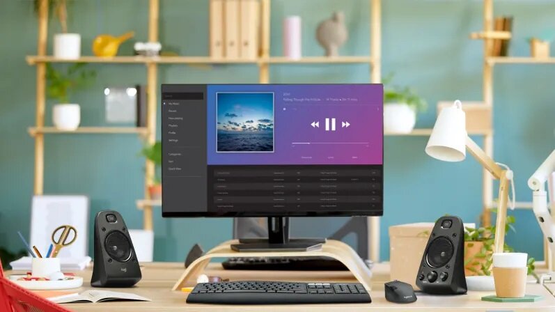 Głośniki Logitech Z623 980-000403 czarne głośniki widoczne na biurku, na ekranie monitora aplikacja do odtwarzania muzyki