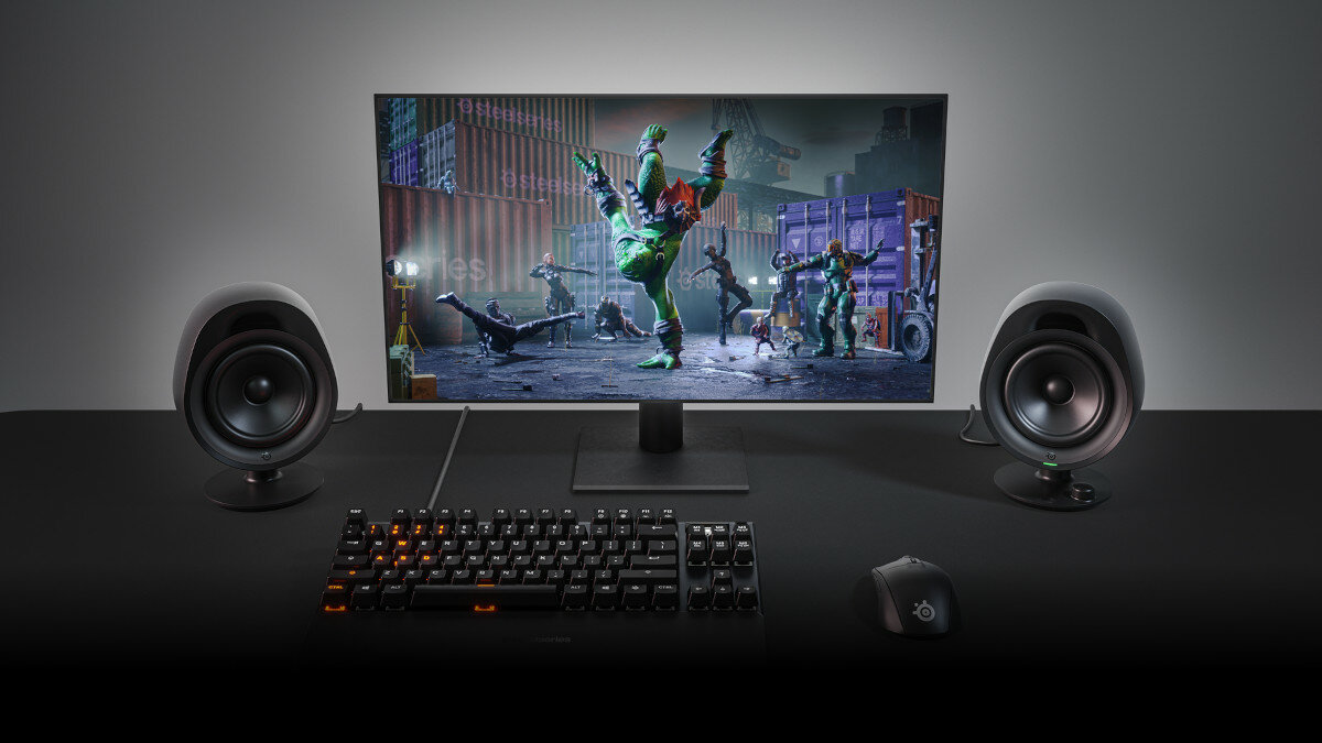 Głośniki SteelSeries Arena 3 wraz z klawiaturą, myszką i monitorem na blacie