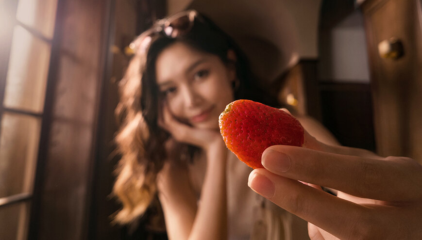 Kamera DJI Osmo Pocket 3 widok na kadr przedstawiający kobietę z truskawką trzymaną w dłoni