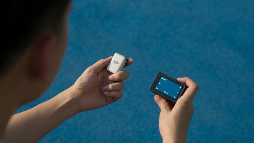 Nadajnik DJI Mic 2 grafika przedstawia mężczyznę trzymającego kamerę oraz nadajnik