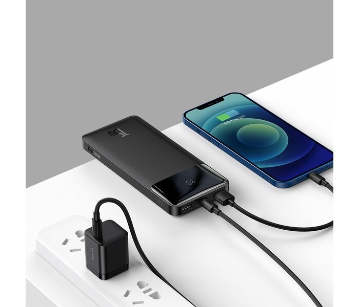 Powerbank Baseus Bipow 10000 mAh czarny pod skosem na stole w trakcie ładowania smartfona