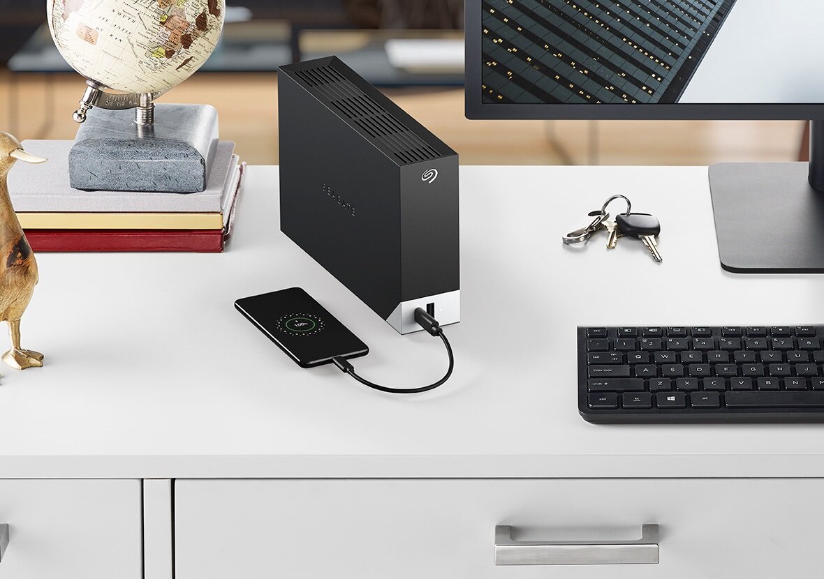 Dysk Seagate One Touch Desktop HUB 4TB STLC4000400 ustawiony pionowo na biurku podłączony do telefonu