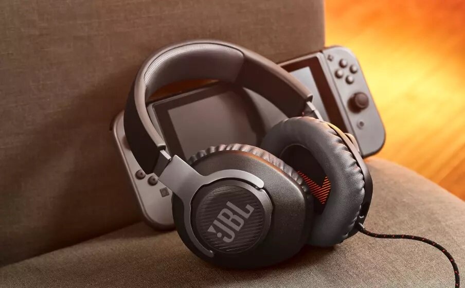 Słuchawki JBL Quantum 100 obok konsoli do gier