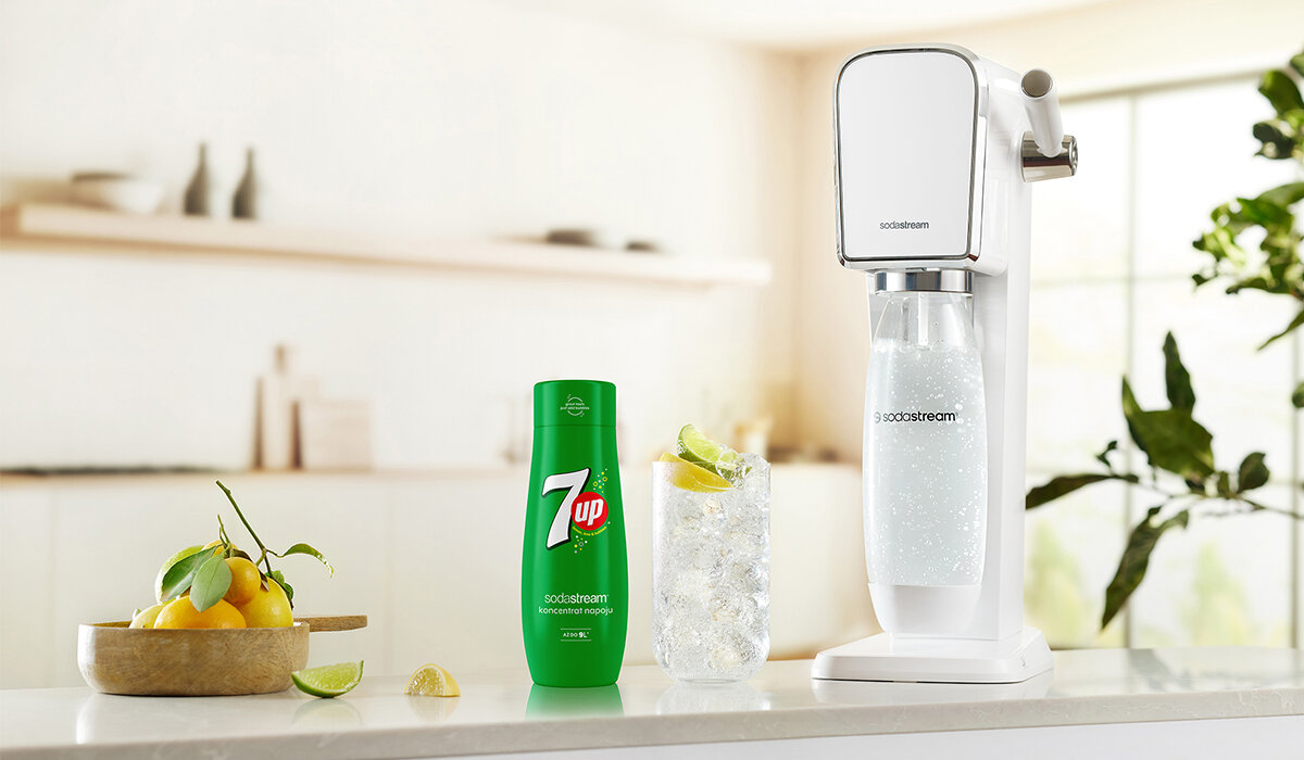 Syrop SodaStream 7UP 440ml widok na butelkę syropu wraz z gotowym napojem i urządzeniem na tle kuchni