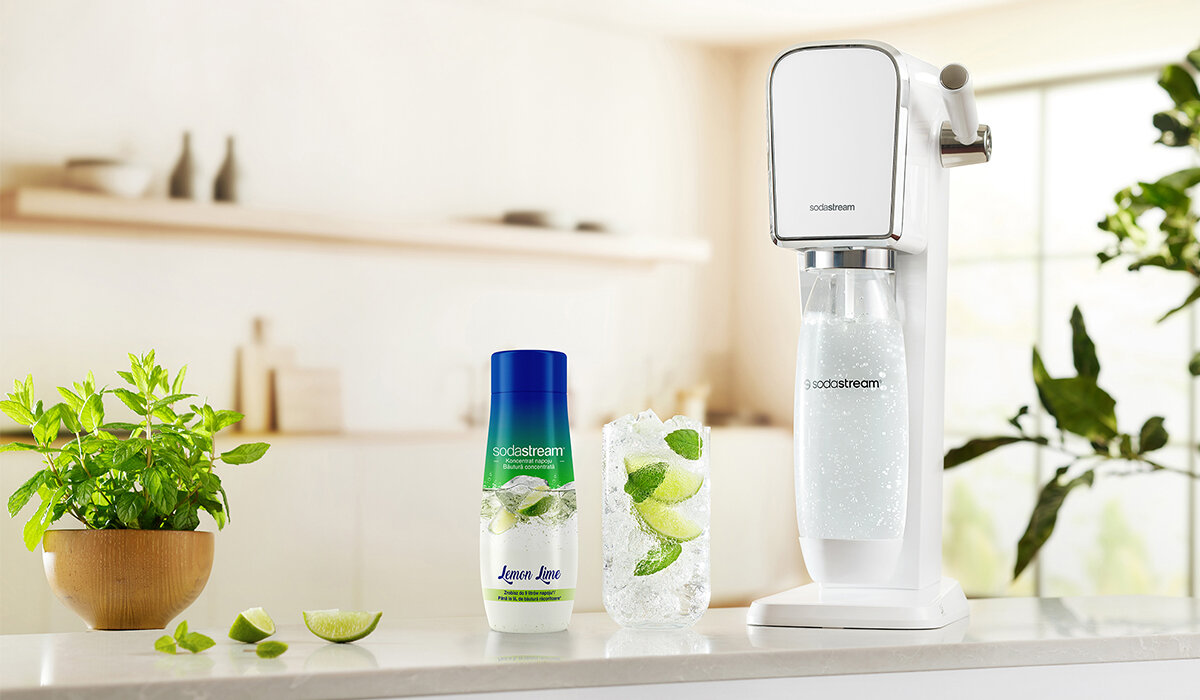 Syrop SodaStream Lemon Lime 440ml widok na butelkę syropu wraz gotowym napojem i urządzenie na tle kuchni 