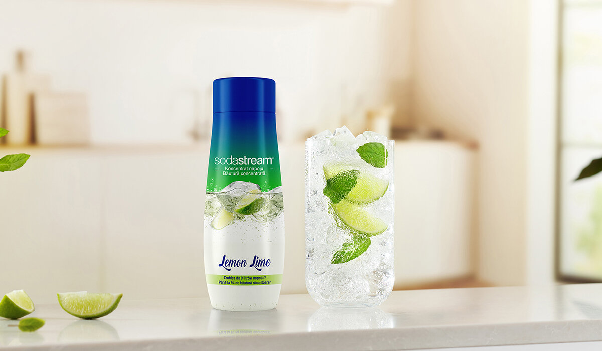 Syrop SodaStream Lemon Lime 440ml butelka syropu wraz z gotowym napojem na tle kuchni