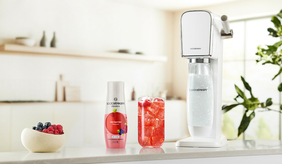 Syrop SodaStream Owoce leśne 440ml widok na butelkę syropu wraz z gotowym napojem i saturatorem na tle kuchni