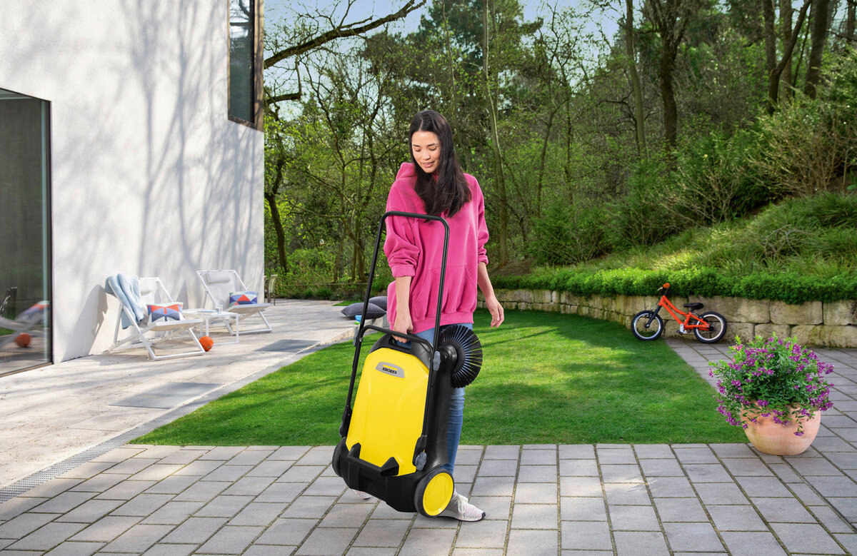 Zamiatarka Karcher S 4 Twin w rękach kobiety będąca na ogrodzie