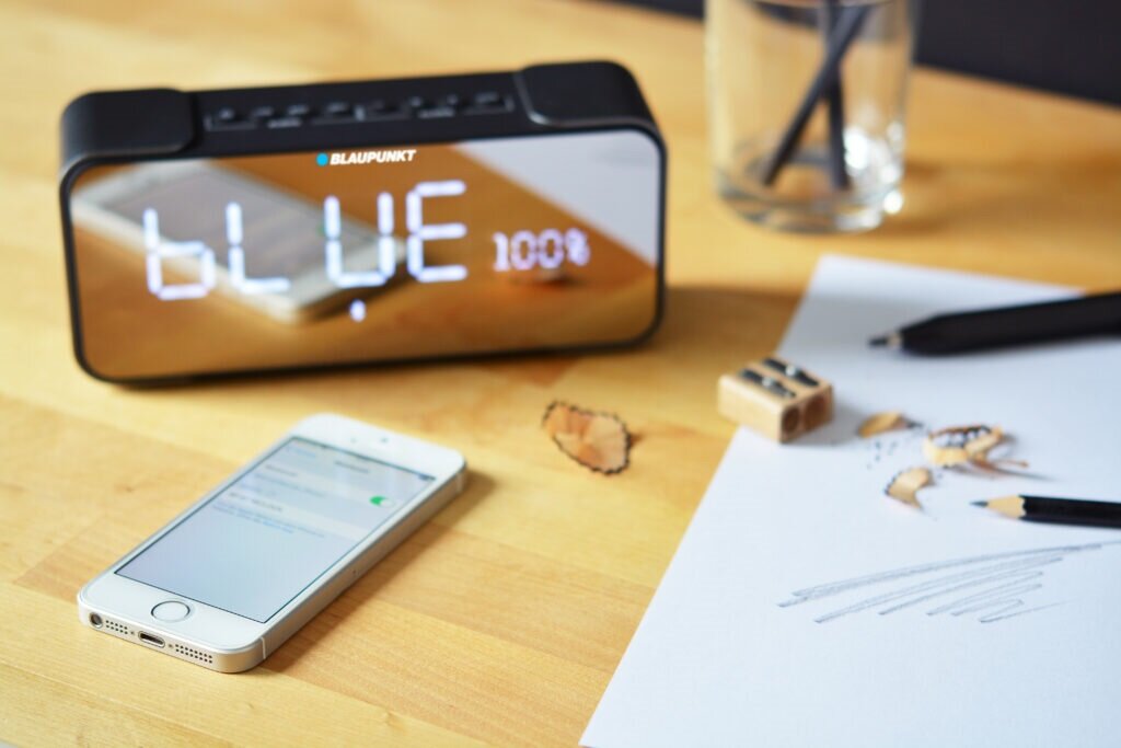 Głośnik Blaupunkt BT16CLOCK FM Bluetooth na stoliku obok telefonu