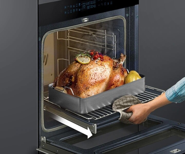 Piekarnik Samsung NV75N7626RB Dual Cook Flex czarny zbliżenie na potężnego kurczaka wyciąganego z piekarnika