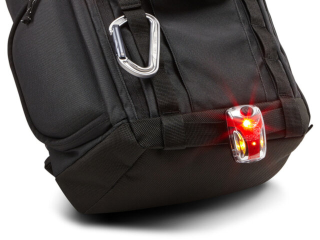 Plecak Thule Subterra 3203037 z przypiętym do uchwytu oświetleniem rowerowym i karabińczykiem