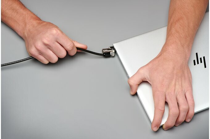 Kabel blokady do laptopa Kensington NanoSaver czarny ręce mężczyzny podłączającego kabel do laptopa
