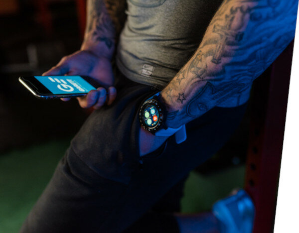 Smartwatch Garett Multi 4 Sport na ręce mężczyzny który trzyma telefon w dłoni