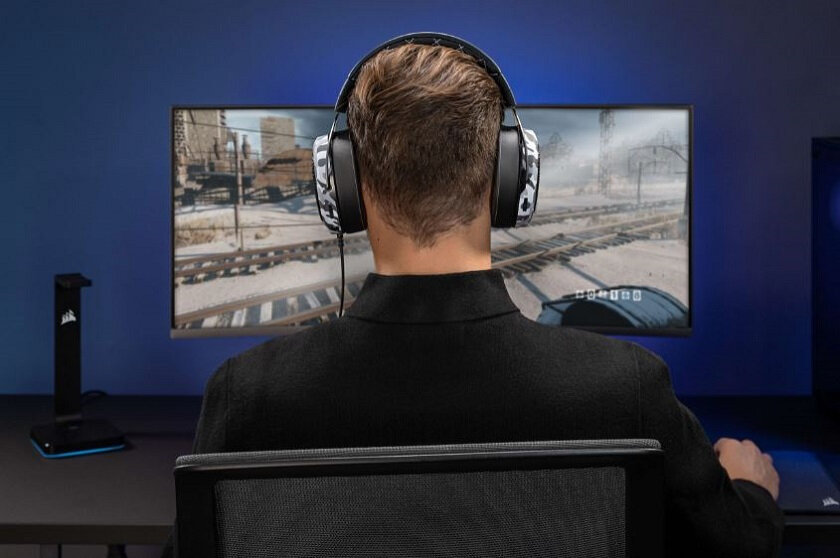 Słuchawki Corsair HS60 Haptic CA-9011225-EU mężczyzna  z słuchawkami przed monitorem