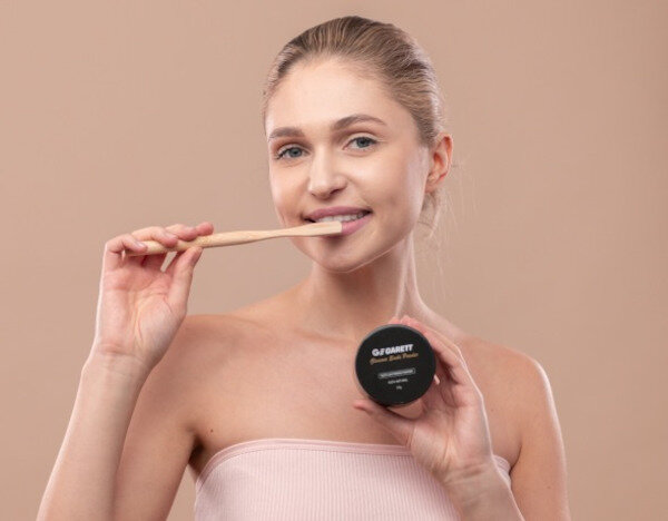 Węgiel aktywny do wybielania zębów Garett Beauty Smile Powder + Szczoteczka bambusowa widok na puder i szczoteczkę podczas użycia