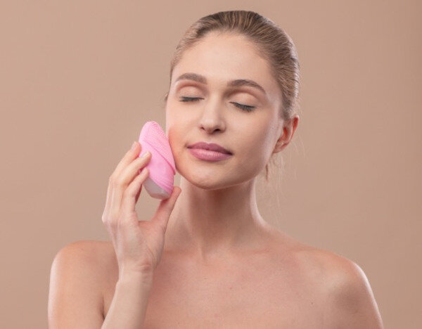 Szczoteczka soniczna do twarzy Garett Beauty Clean różowa widok na urządzenie przyłożone do twarzy