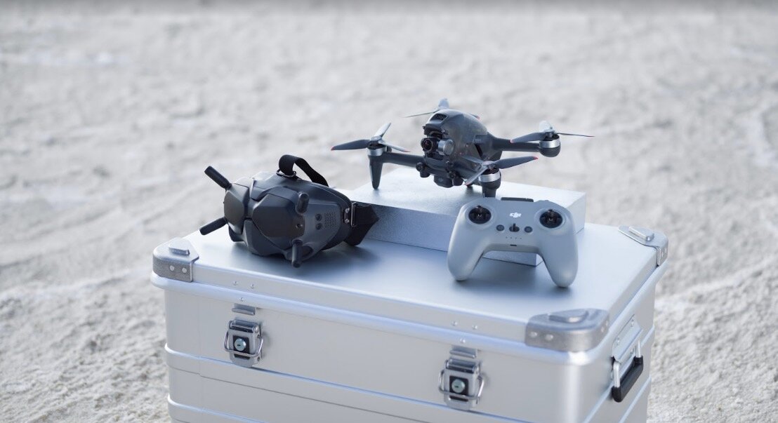 Dron DJI FPV szary widok od góry na dron i kontroler leżące na skrzynce