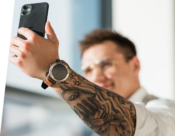 Smartwatch Garett Men 4S srebrno-czarny, stalowy widok na smartwatch podczas robienia selfie telefonem
