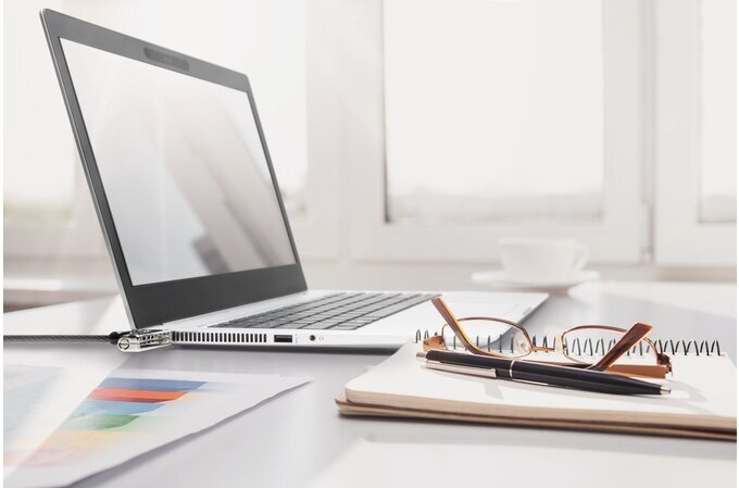 Blokada laptopa Kensington Slim NanoSaver resettable podłączona pod laptopa na biurku