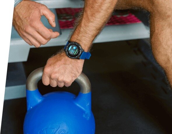 Smartwatch Garett Sport Activity różowy widok na zegarek założony podczas ćwiczeń na siłowni