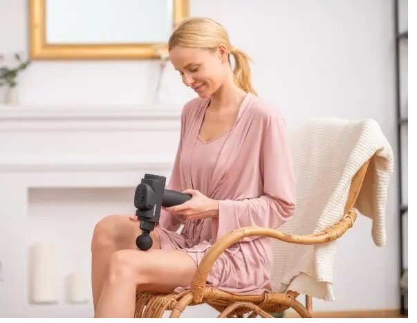Pistolet do masażu Garett Beauty Powerful używany przez kobietę