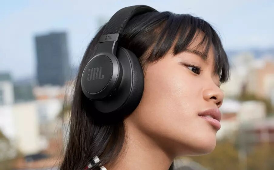 Słuchawki JBL Live 660NC LIVE660NCBLK kobieta ze słuchawkami na uszach widok na jedną słuchawkę od boku
