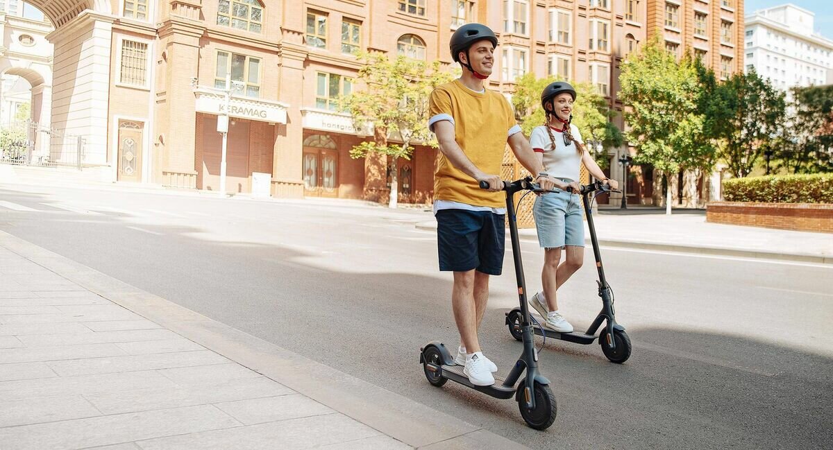 Hulajnoga elektryczna Xiaomi Mi Scooter 3 Szara jadąca dziewczyna i chłopak na hulajnodze