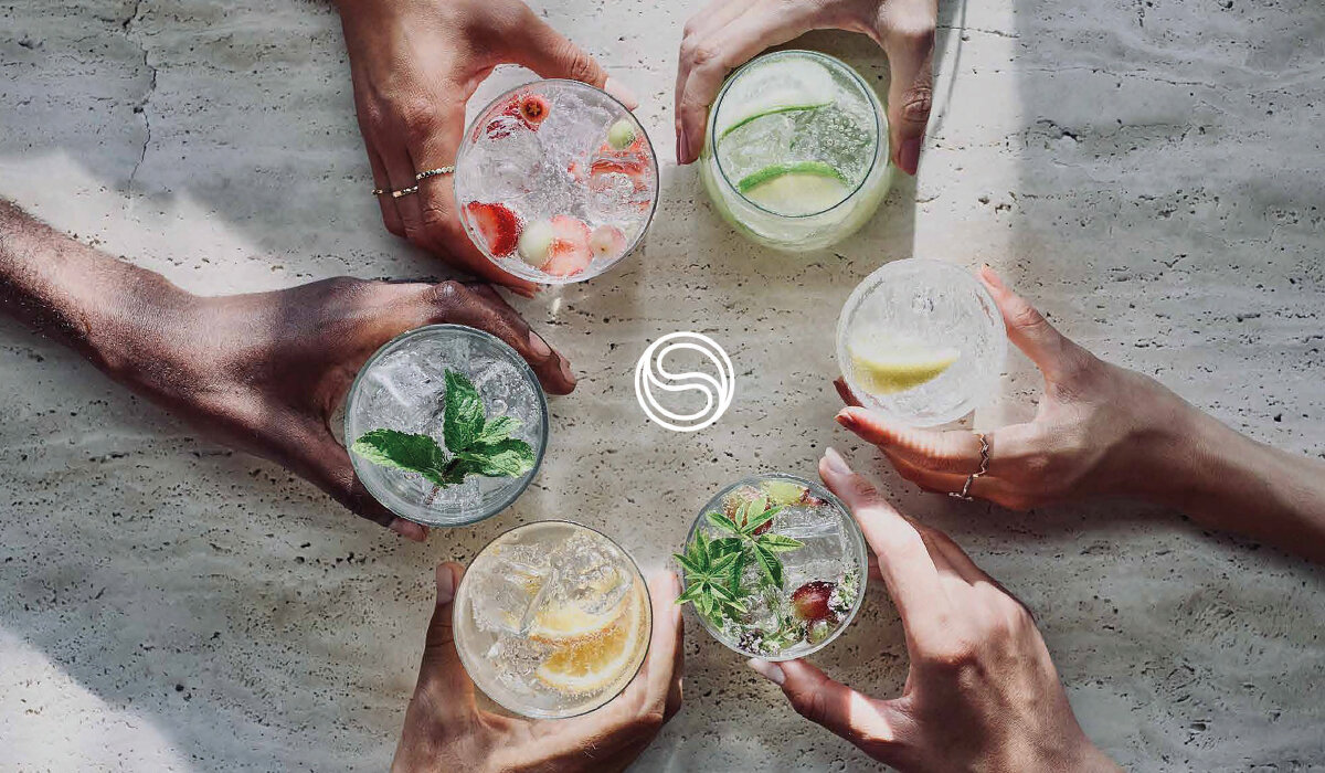 Saturator SodaStream Terra grafika przedstawia szklanki z gotowymi napojami trzymane w rękach