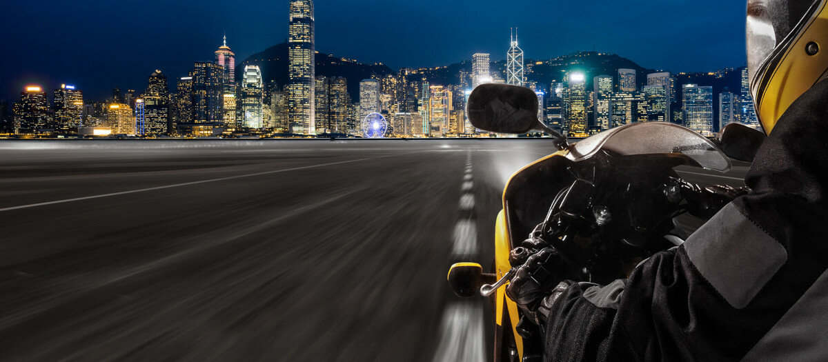 Rejestrator motocyklowy MIO MiVue M760D widok na motocyklistę pędzącego w stronę miasta