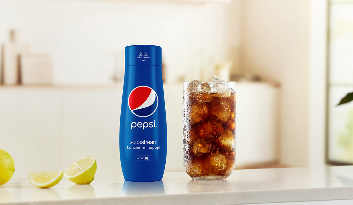 Syrop SodaStream Pepsi 440ml butelka syropu wraz z gotowym napojem na tle kuchni