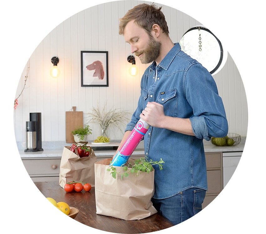 Cylinder SodaStream Różowy widok na mężczyznę wyjmującego z torby na zakupy cylinder