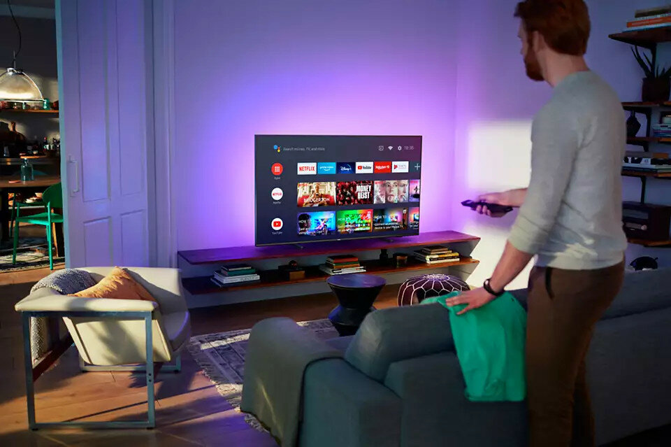 Telewizor Philips 43PUS7906 widok na włączony telewizor w domowej scenerii od frontu z wyświetlanym smarttv