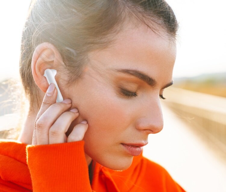 Słuchawki TCL MOVEAUDIO S150 widok na kobietę naciskającą palcem słuchawkę włożoną do ucha