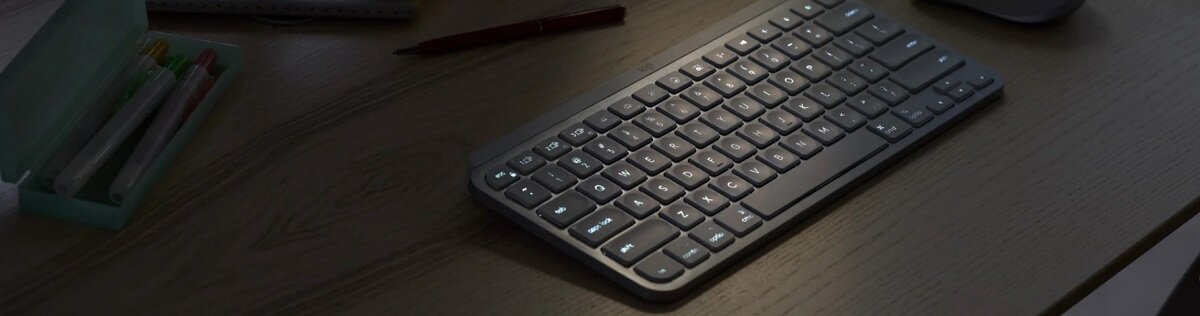 Klawiatura Logitech MX Keys Mini jasnoszara klawiatura w ciemnym pomieszczeniu