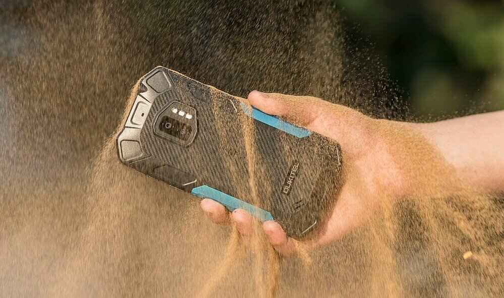 Smartfon Oukitel WP12 4/32 GB czarny lecacy pył na smartfon trzymany w dłoni