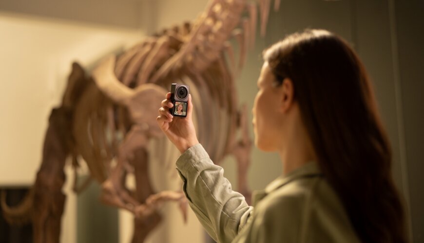 Kamera DJI Action 2 Dual-Screen Combo widok na kobietę trzymającą kamerę z podłączonym modułem z ekranem