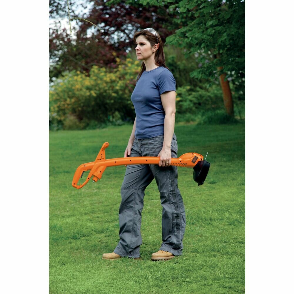 Podkoszarka do trawy Black&Decker GL360 Żyłkowa trzymana w ręku przez kobietę będąca na trawniku