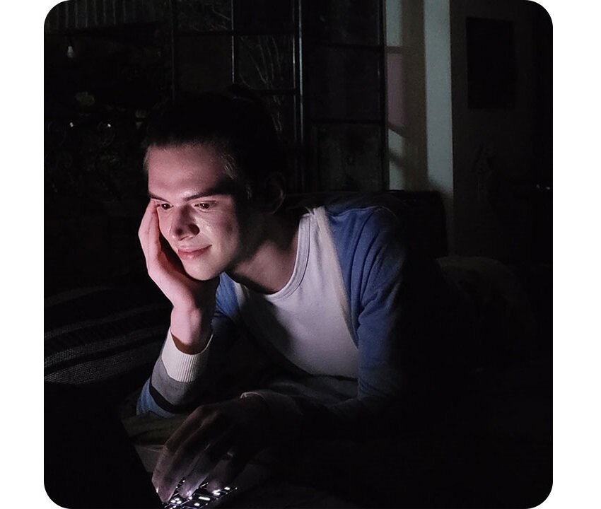 Smartfon Samsung Galaxy S21 FE 5G SM-G990 SM-G990BLVDEUE widok na mężczyznę korzystającego z laptopa w nocy