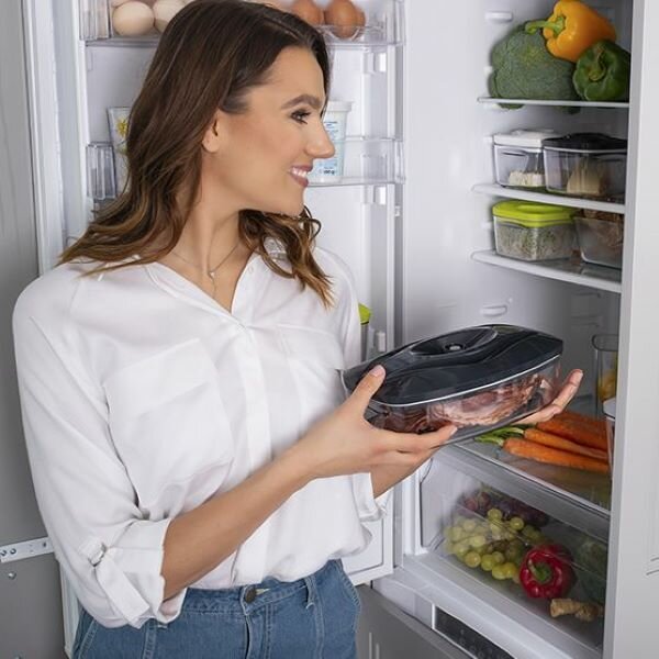 Pojemnik próżniowy SeeYoo 1,5L + Pompka manualna, w zastosowaniu w scenerii kuchennej, kobieta z pojemnikiem w dłoni na tle lodówki