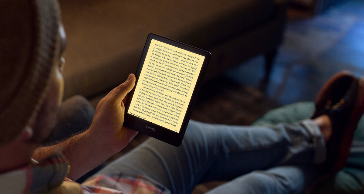 Czytnik e-Booków Amazon Kindle Paperwhite 5 trzymany w ręce przez leżącego mężczyznę