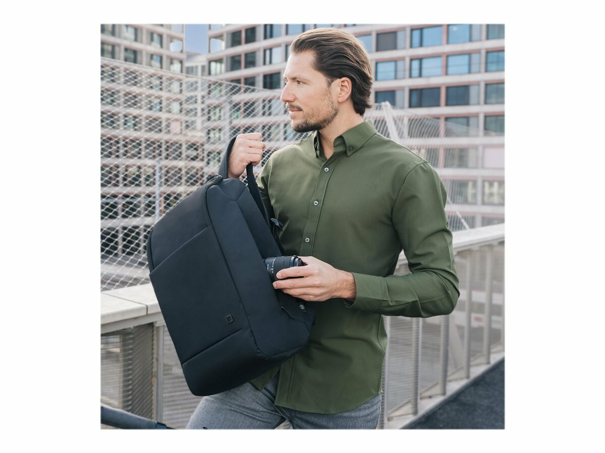 Plecak na laptopa Dicota Eco Motion 13 - 15,6' mężczyzna wkładający obiektyw do plecaka
