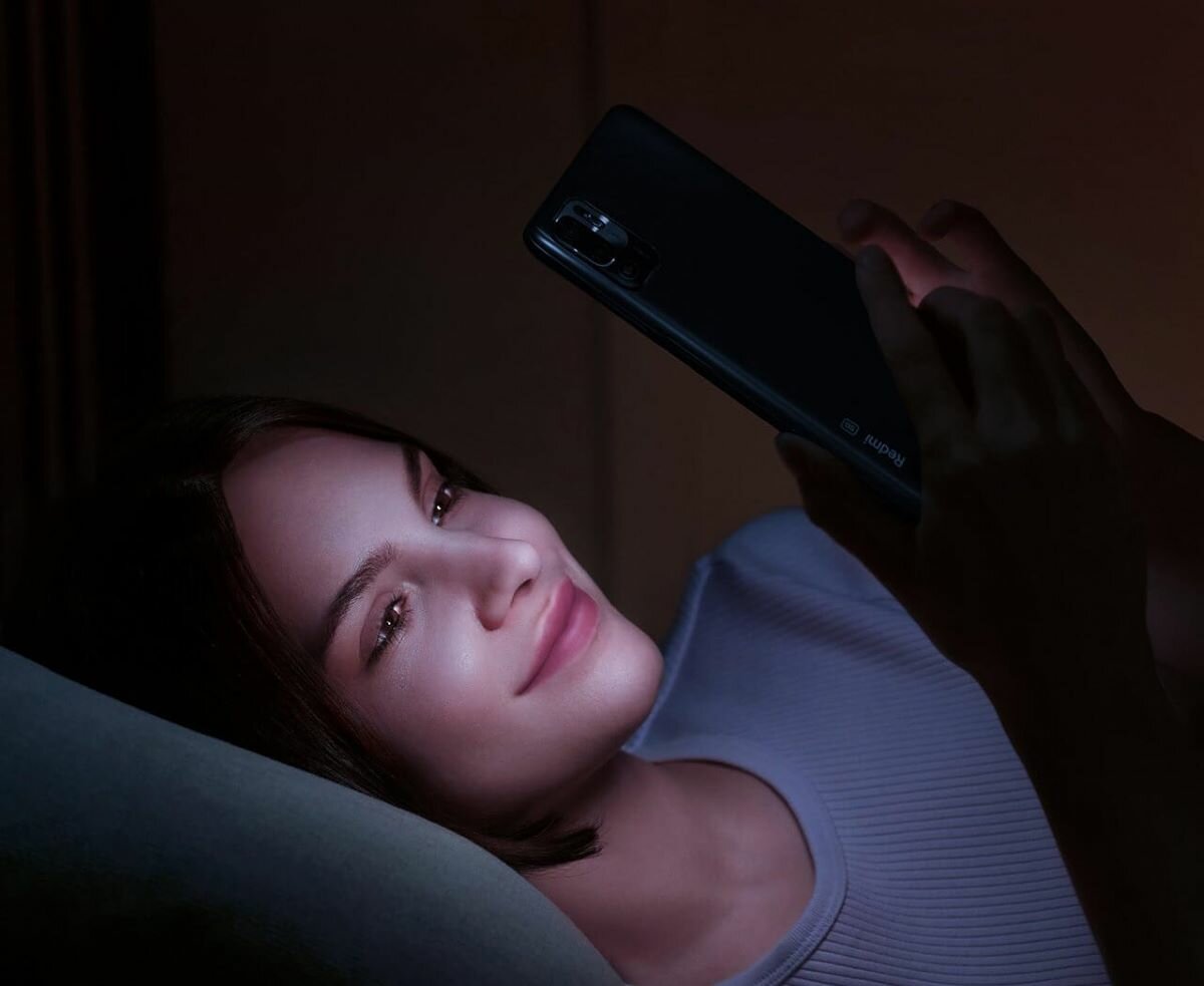 Smartfon Xiaomi Redmi Note 10 nocą kobieta ze smartfonem w dłoni