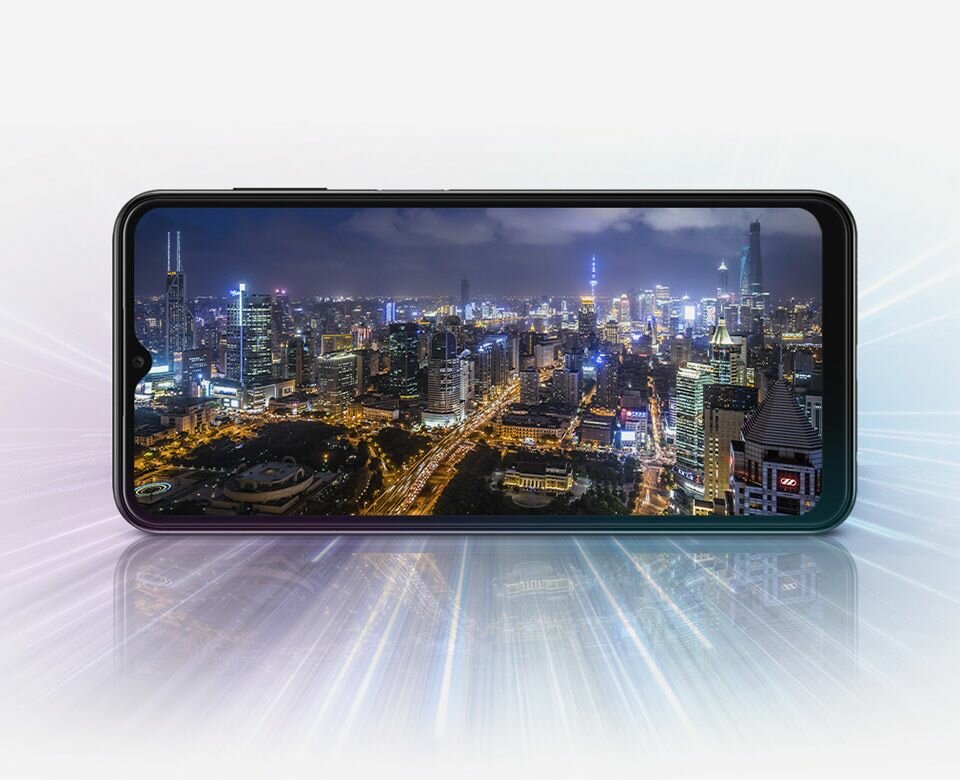 Smartfon Samsung Galaxy A13 SM-A135F bokiem an wyświetlaczu miasto nocą