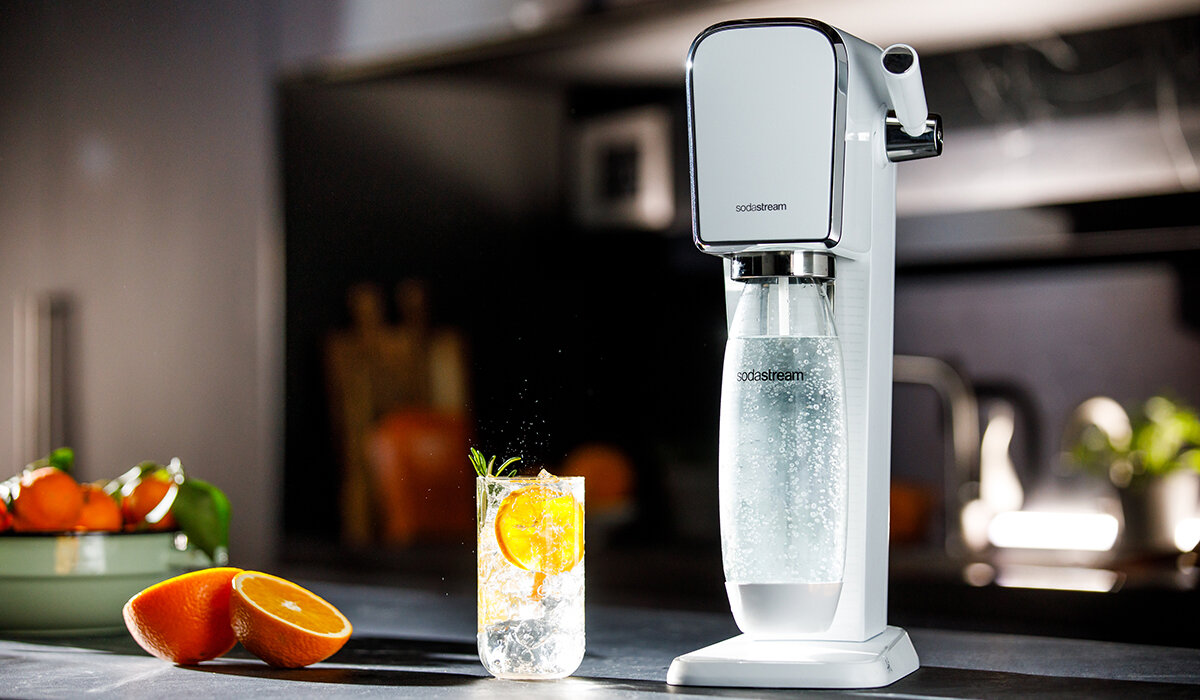 Saturator SodaStream Art grafika predstawia saturator oraz szklankę z wodą na tle kuchni